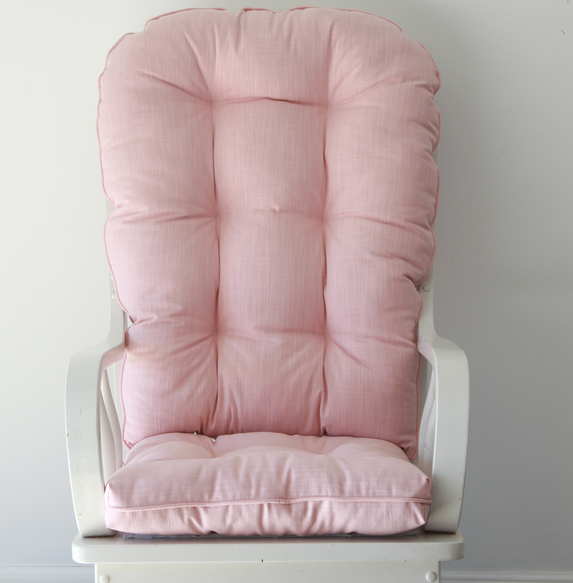Solid blush pink upholstery fabric on a set of round top glider rocker cushions